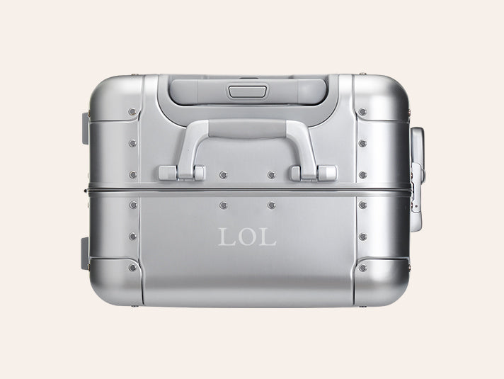 An Aluminum Away suitcase with engraving on the top center of the suitcase